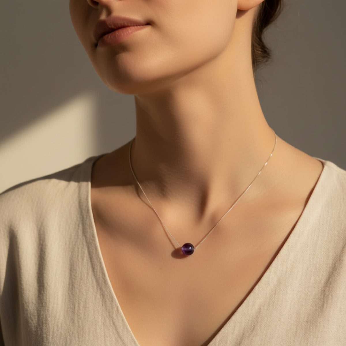 Model wearing simple amethyst birthstone necklace with small round gemstone