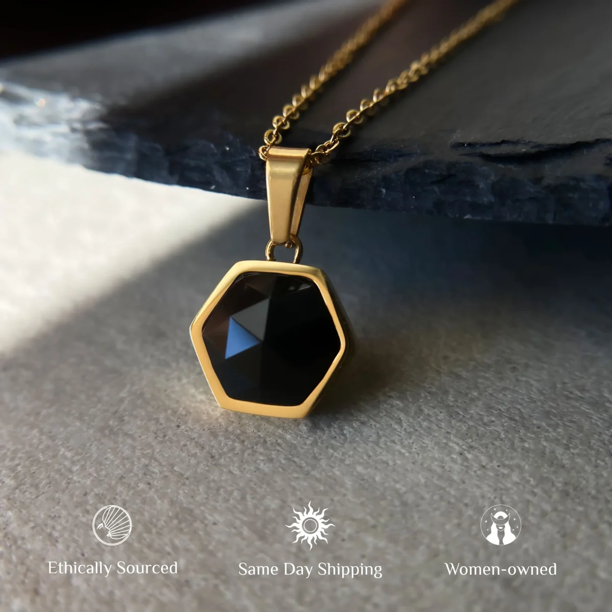 hexagonal black agate pendant crystal necklace 18k gold plated amulet jewelry for women black agate necklace standing on luxury surface