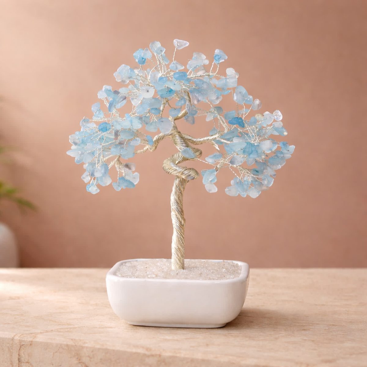 Aquamarine crystal tree bonsai with blue gemstone leaves in a white ceramic base for desk decor