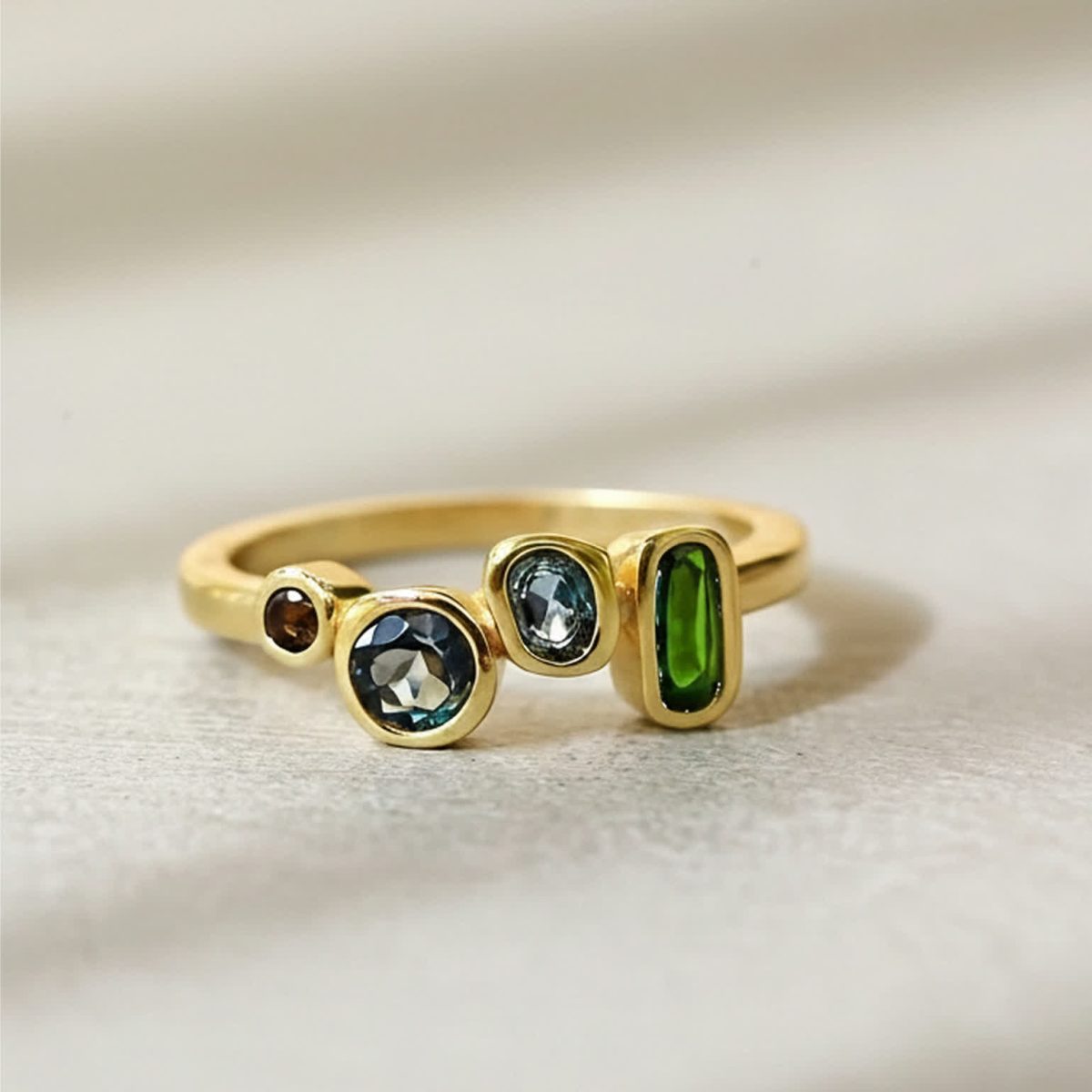 Studio photograph of london blue topaz ring highlighting warm gold plating and gemstone contrast.