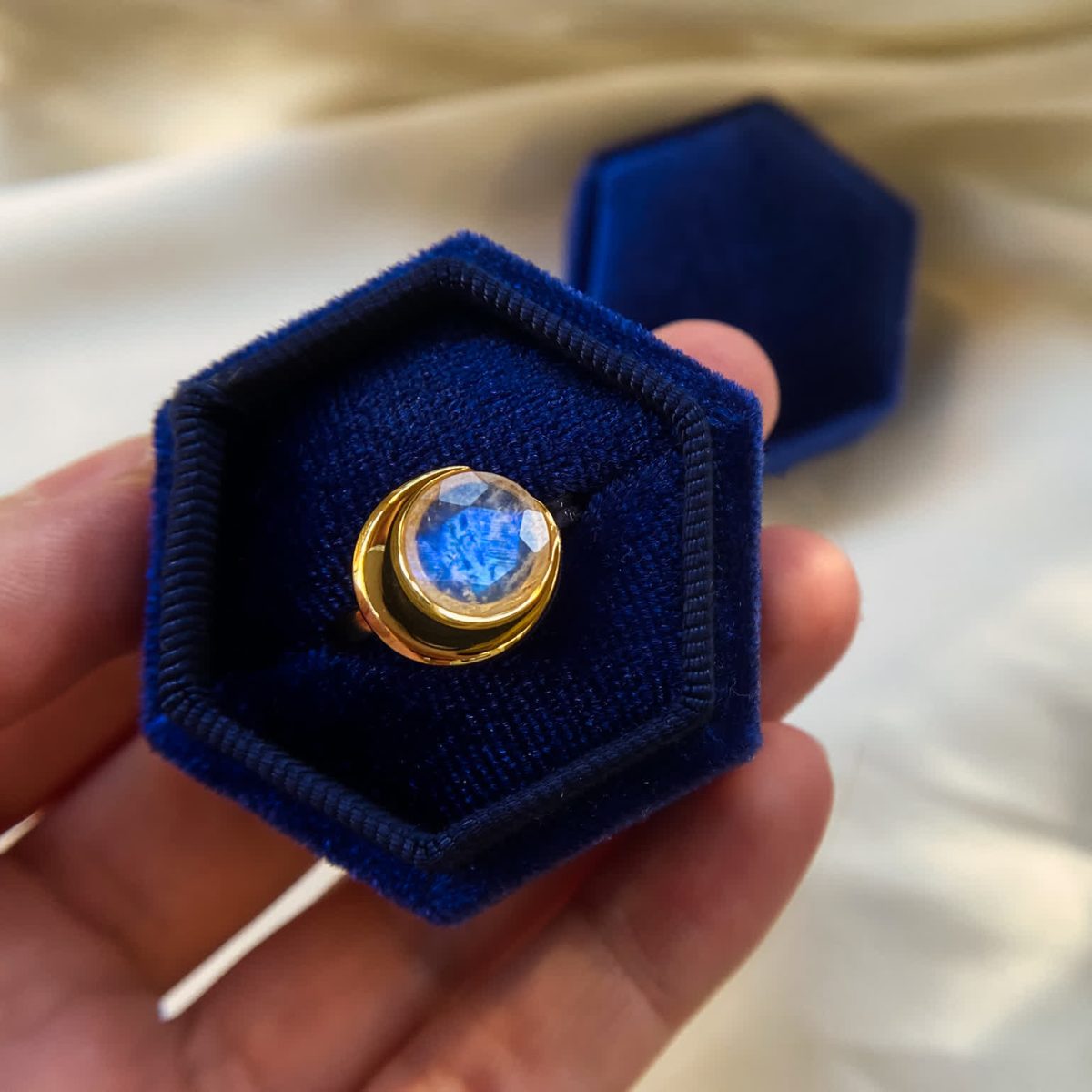 Moonlight ring displayed in a blue velvet gift box with gold over silver band.