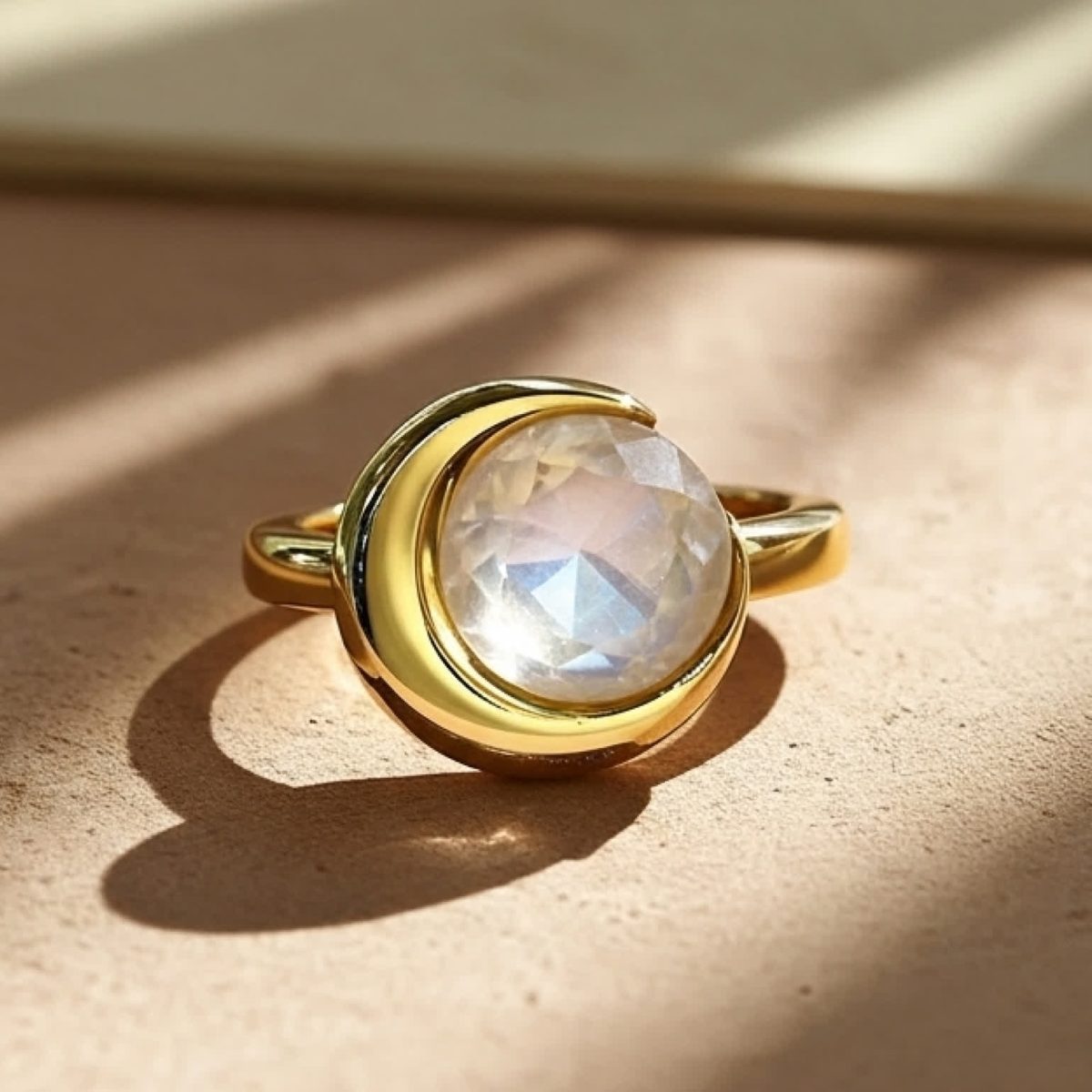 Front view of a moonstone ring with crescent gold setting and soft moonlight glow.