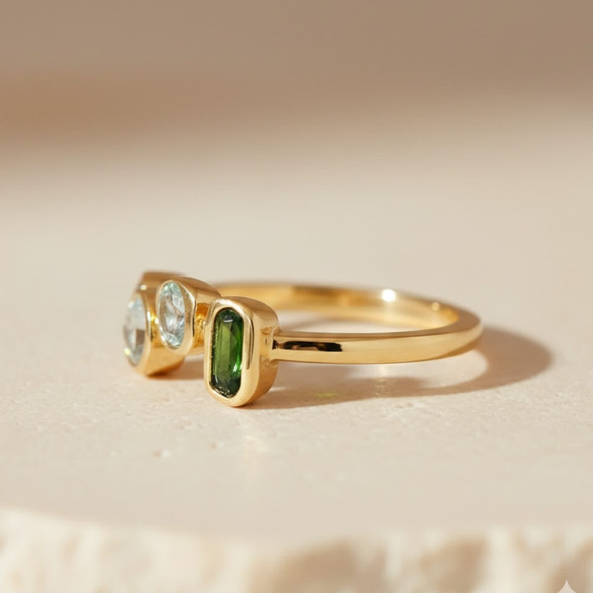 Side profile of a multi-colored gemstone ring highlighting polished gold band and stone settings.