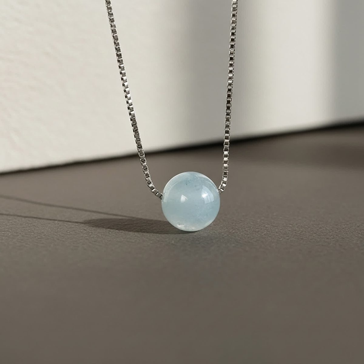March birthstone aquamarine necklace layered with delicate silver chains