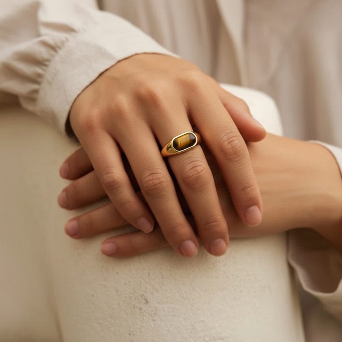 Elegant tiger eye ring styled on hand with casual cream outfit.