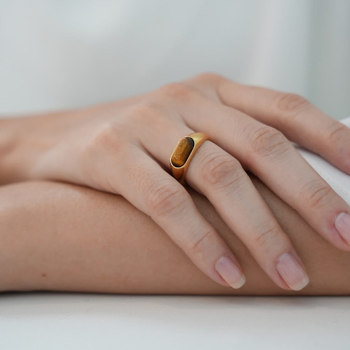 Minimalist gold ring with natural tiger eye gemstone styled on fingers